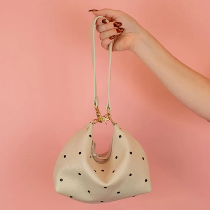 Creamy Off-White Curved Slouchy Pouch With Even Black Dot Motifs, Polished Warm Gold Hardware And Thin Matching Wrist Carry Strip
