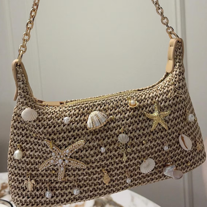 Natural Sandy Beige Curved Woven Hobo Pouch With Ocean Shell Starfish Embellishments, Gold Toned Slide Closure And Linked Metal Carry Chain