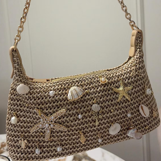 Natural Sandy Beige Curved Woven Hobo Pouch With Ocean Shell Starfish Embellishments, Gold Toned Slide Closure And Linked Metal Carry Chain