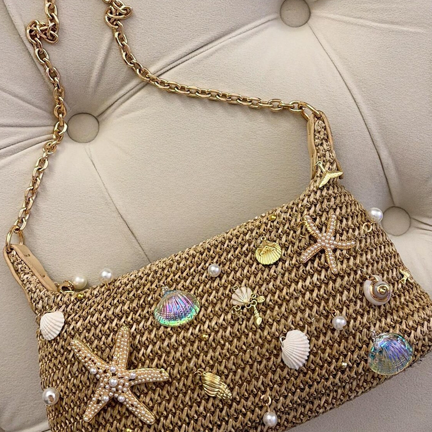 Natural Sandy Beige Curved Woven Hobo Pouch With Ocean Shell Starfish Embellishments, Gold Toned Slide Closure And Linked Metal Carry Chain