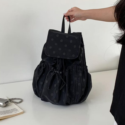 Solid Black Subtle Dot Pattern Slouchy Drawstring Rucksack With Square Overlay Flap, Ruched Side Storage Panels And Compact Fabric Top Carry Loop
