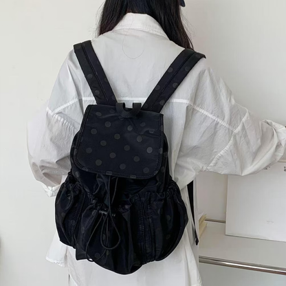 Solid Black Subtle Dot Pattern Slouchy Drawstring Rucksack With Square Overlay Flap, Ruched Side Storage Panels And Compact Fabric Top Carry Loop